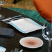A Villeroy & Boch Amarah aquamarine porcelain rectangular gourmet plate on a table with a glass of wine.