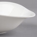 A white Villeroy & Boch deep bowl with a curved edge on a gray surface.