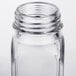 A close up of a clear glass square salt and pepper shaker with a lid.
