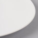 A close-up of a Villeroy & Boch white porcelain flat coupe plate with a white rim.