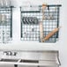 A Metro SmartWall G3 dish wash task station in a kitchen with utensils on the wall.