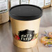 A Choice paper soup container with a black lid containing soup.