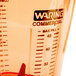 A close-up of a Waring orange blender jar with a label that says "Waring Commercial" on the counter.