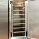 A Regency aluminum sheet pan rack with trays of food on it in a metal oven.