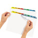 A hand holding Avery Index Maker multi-color divider tabs with clear labels.