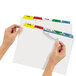 A hand holding a file folder with Avery Index Maker multi-color tabs.