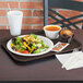 A Vollrath brown plastic fast food tray with a salad, muffin, and cup of soup on it.