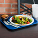 A Vollrath fast food tray with a plate of salad, muffin, and white utensils.