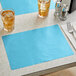A table set with a blue Choice paper placemat and two glasses of ice water.
