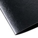 A close-up of a black leather Menu Solutions wine list cover.
