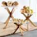 A Tablecraft 3-piece acacia riser set with trays of fruit and pastries on a table.