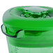 A close-up of a green plastic Waring blender jar with a lid.