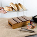 A Tablecraft Gastronorm acacia wood serving and display crate holding a variety of breads.