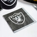 A black and white Creative Converting Las Vegas Raiders beverage napkin with a Raiders logo.