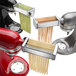 A KitchenAid pasta roller and cutter attachment with a variety of pasta.