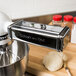 A KitchenAid stand mixer with the Pasta Roller Attachment and Cutter Set on a counter.