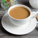 A Villeroy & Boch white porcelain saucer with a cup of coffee and a cookie.