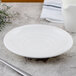 A white Villeroy & Boch porcelain saucer on a table with a white jug.