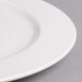 A close-up of a Villeroy & Boch white porcelain round platter with a pattern.