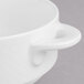 A close up of a Villeroy & Boch white porcelain soup cup with a handle.