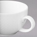 A close-up of a Villeroy & Boch white porcelain cup with a handle.