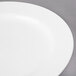 A Villeroy & Boch white porcelain flat plate with a circular rim on a gray surface.