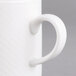 A close-up of a Villeroy & Boch white porcelain mug with a handle.
