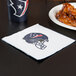 A Creative Converting Houston Texans luncheon napkin with a football helmet logo next to a plate of chicken wings.
