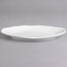 A white porcelain oval dish with a curved edge.