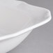 A close-up of a Villeroy & Boch white porcelain square salad bowl with a wavy rim.