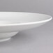 A white porcelain deep plate with a small rim and a well.