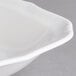 A close-up of a Villeroy & Boch white porcelain square salad bowl with a curved rim.