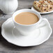 A Villeroy & Boch white porcelain saucer with a cup of coffee and a plate of pastries.