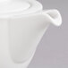 A close up of a Villeroy & Boch white porcelain teapot with a lid.