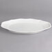 A Villeroy & Boch white porcelain oval flat plate with a curved edge.