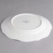 A Villeroy & Boch white porcelain flat plate with a curved edge.