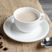A Villeroy & Boch white porcelain saucer with a cup of coffee and spoon.