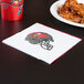 A Tampa Bay Buccaneers luncheon napkin with the team's logo next to a plate of chicken wings.