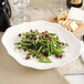 A Villeroy & Boch white porcelain oval plate with green beans with cranberries and feta cheese.