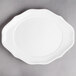 A white Villeroy & Boch porcelain oval flat plate with a curved edge.