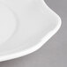 A close up of a Villeroy & Boch white porcelain oval flat plate with a curved rim.