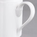 A close-up of a white Villeroy & Boch porcelain mug with a handle.