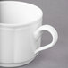 A close-up of a Villeroy & Boch white porcelain stackable cup with a handle.