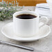 A Villeroy & Boch white porcelain stackable cup of coffee on a saucer.