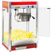 A Paragon red popcorn machine with a yellow bowl and a bucket of popcorn.