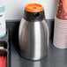 A stainless steel Choice insulated thermal coffee carafe with an orange lid.