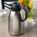 A silver and black Choice thermal coffee carafe on a table.