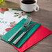 A fork and knife on a Merry Christmas placemat next to a cup of coffee.