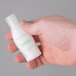 A hand holding a small white bottle of Dial Restore Hand & Body Lotion.