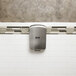 An Excel ThinAir high-efficiency hand dryer with a brushed stainless steel cover on a white tile wall.